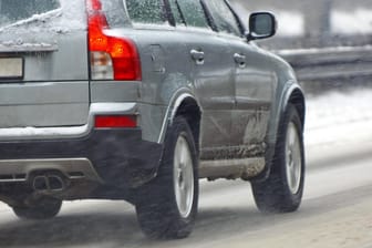 Ein Auto fährt über eine verschneite Straße (Symbolbild): Der Mann erklärte, seine Winterreifen seien noch in Spanien.