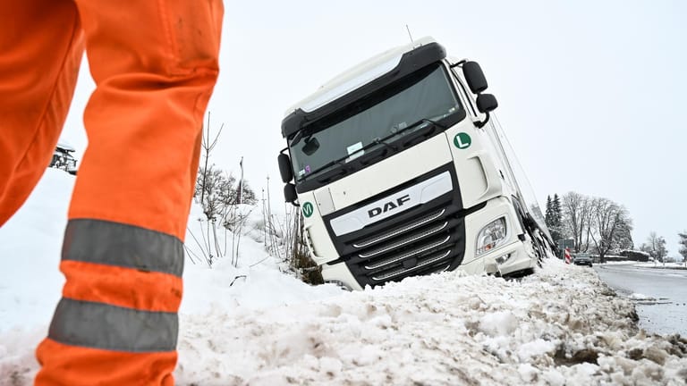 Ein Laster liegt in Ravensburg im schneebedeckten Graben: Der Wagen ist am Donnerstagmorgen auf spiegelglatter Straße auf die Seite gerutscht.