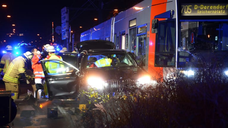 Rettungskräfte befreien eine Frau aus einem Auto, nachdem dieses mit einer Straßenbahn kollidiert ist: Die Fahrerin wurde bei dem Zusammenstoß in Düsseldorf schwer verletzt.