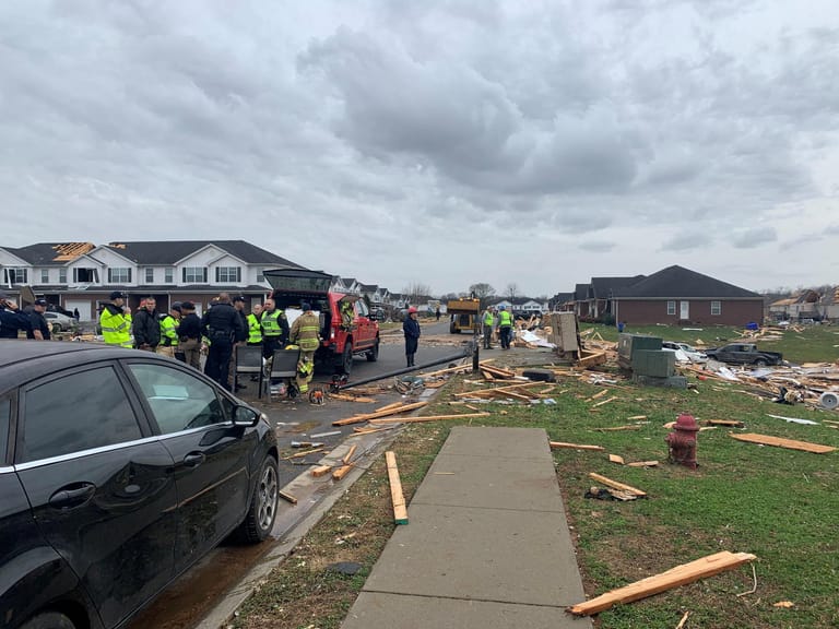 Helfer stehen vor den Trümmern in Bowling Green in Kentucky.