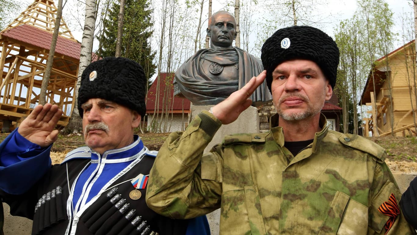 Kosaken vor eine Statue von Wladimir Putin: Der russische Präsident versucht den politischen Einfluss der Gruppe zu stärken.
