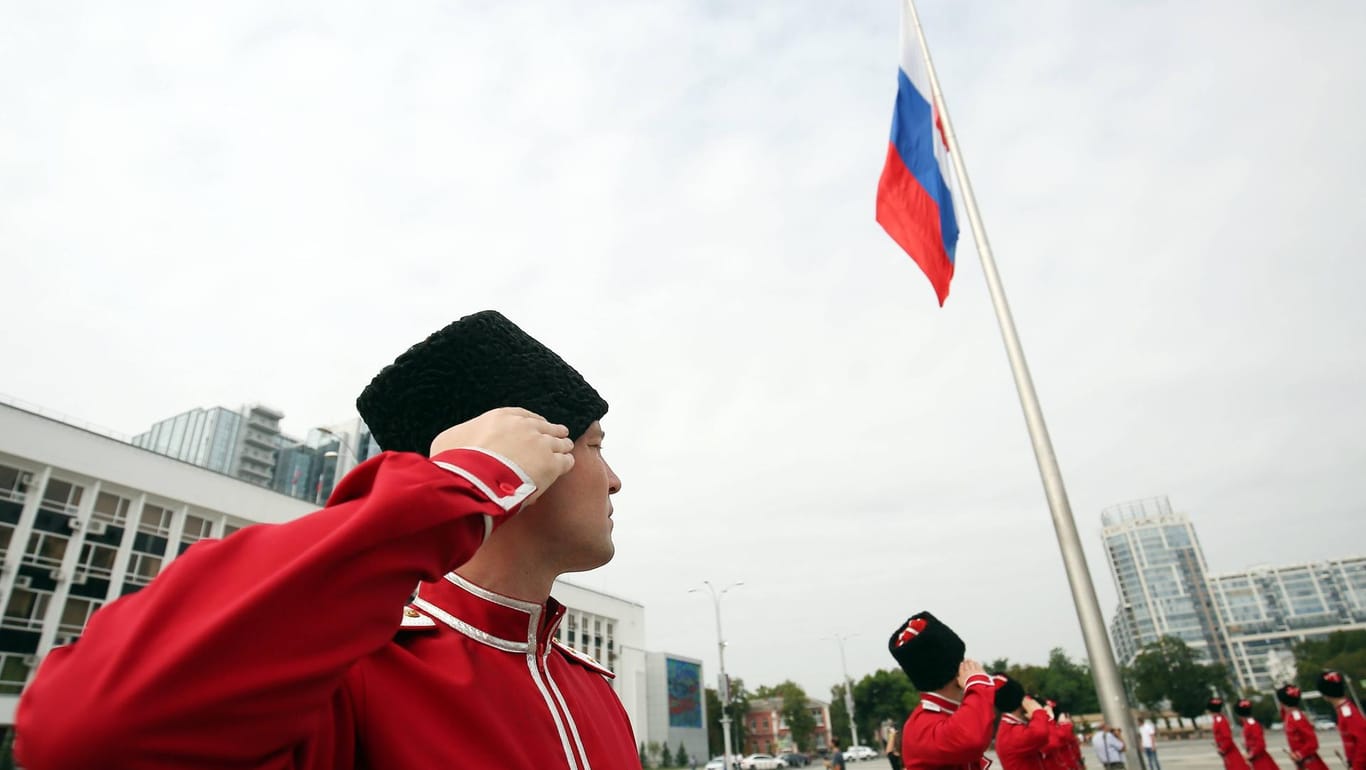 Kosaken salutieren der russischen Flagge am Nationafeiertag: Mittlerweile nimmt die Gruppe auch an Militärparaden teil. (Archivfoto)