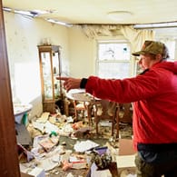 Eine Frau zeigt auf ihr zerstörtes Esszimmer: Sie und ihr Mann haben den Tornado im Keller überlebt.