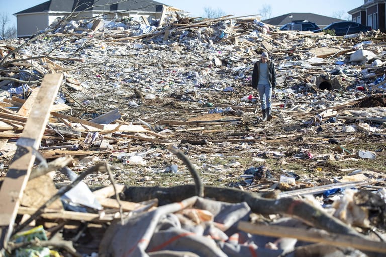 Ein Mann läuft durch die zerstört Überreste einiger Häuser in einer Nachbarschaft in Kentucky.