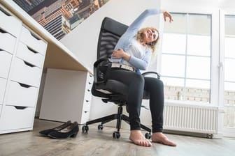 Langes Sitzen kann belasten: Alle 60 bis 90 Minuten sollten Beschäftigte eine kurze Pause für etwas Bewegung einplanen.