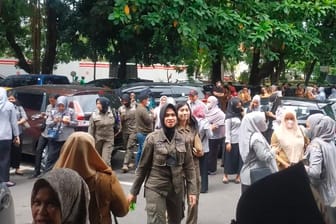 Indonesien, Makassar: Menschen warten draußen, nachdem ein Regierungsgebäude evakuiert worden war.