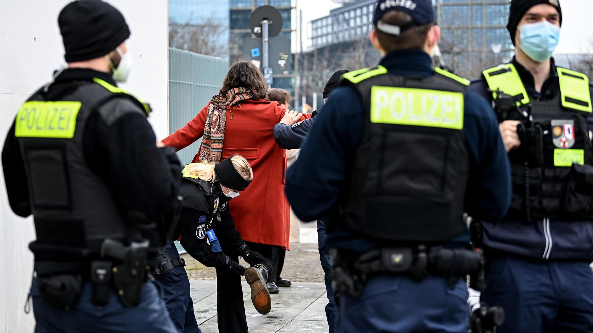 Aktivistin abgeführt: Sie hatte die Parole offenbar an die Mauer geschrieben.