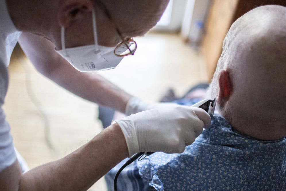 Ein Altenpfleger schneidet einem Patienten den Bart (Symbolbild): In Pflegeeinrichtungen soll bald eine Impfpflicht gelten.