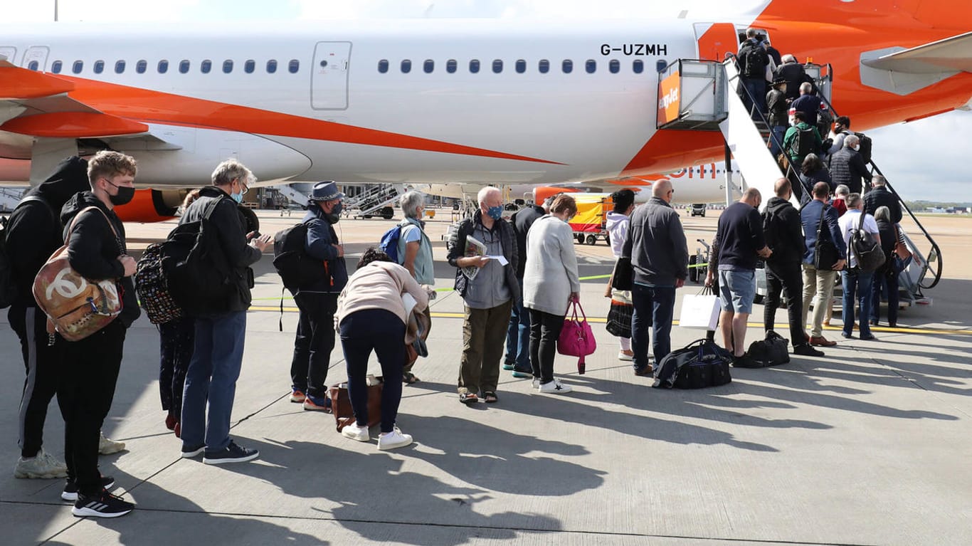 Passagiere auf dem Weg in ein Flugzeug (Symbolbild): Innerhalb von Europa sollen Strecken unter 500 Kilometer nach Wunsch der EU-Kommission klimaneutral werden. Ein starker Schub für die Bahn soll Kurzstreckenflüge weniger attraktiv machen.