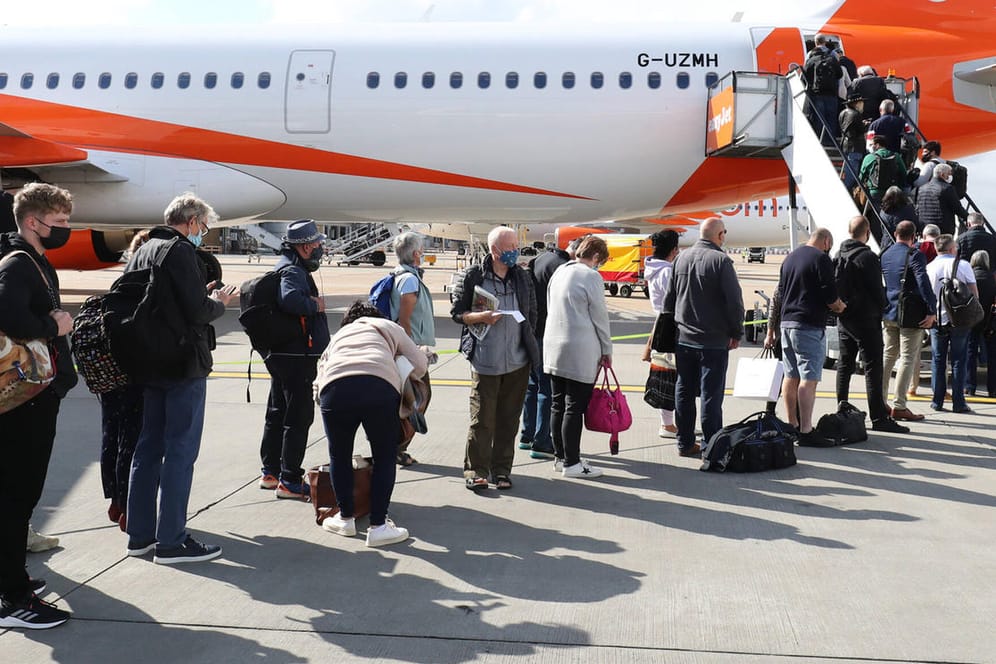 Passagiere auf dem Weg in ein Flugzeug (Symbolbild): Innerhalb von Europa sollen Strecken unter 500 Kilometer nach Wunsch der EU-Kommission klimaneutral werden. Ein starker Schub für die Bahn soll Kurzstreckenflüge weniger attraktiv machen.