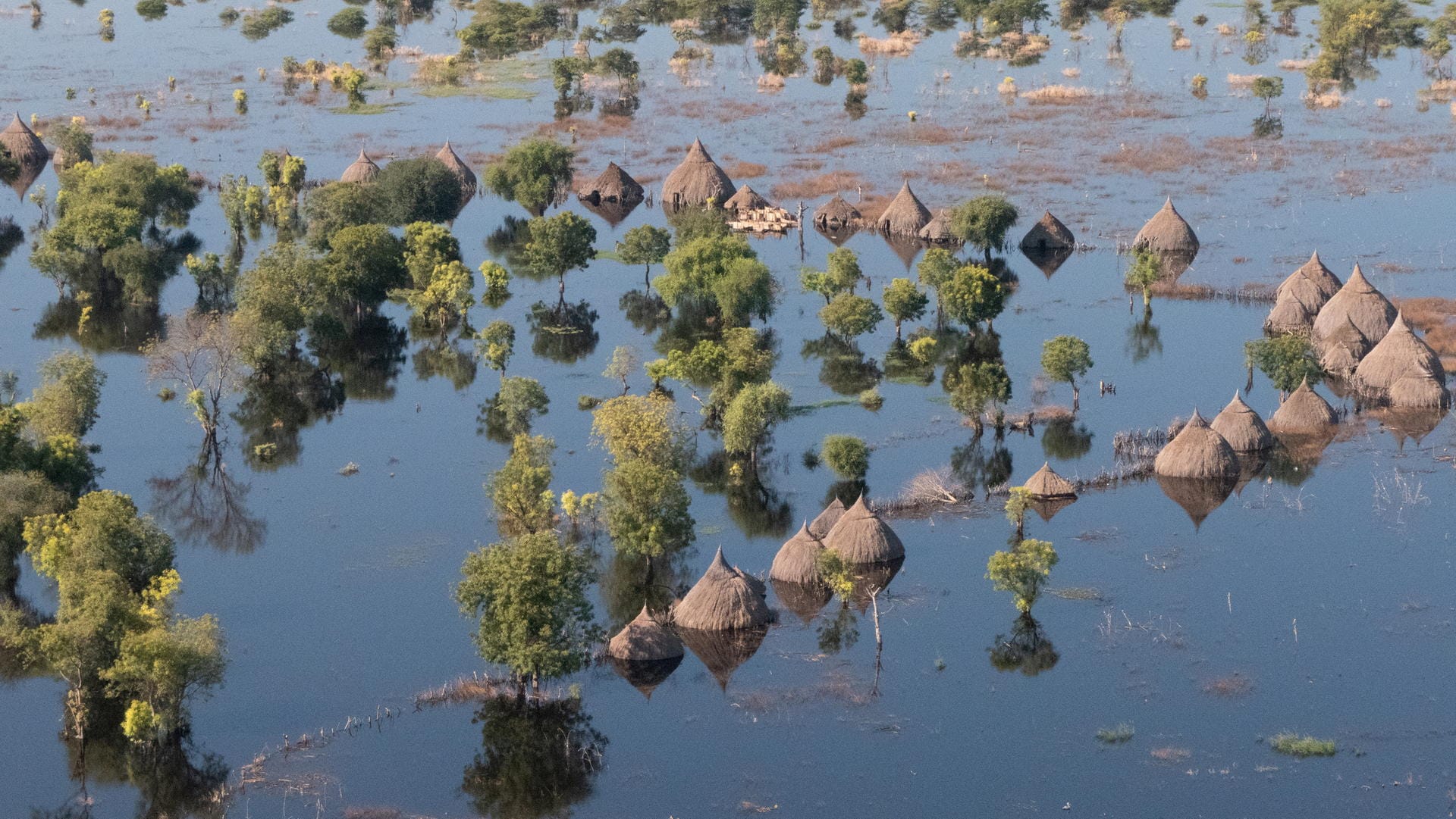 Ein Ort steht unter Wasser: Vor zehn Jahren hat sich der Südsudan vom Sudan abgespalten, zur Ruhe gekommen ist das Land nicht. Zwar hält laut IRC der Friedensvertrag von 2018 weitestgehend, es gibt dennoch zahlreiche kleinere Konflikte. Wegen Fluten, Dürren, der Corona-Krise und der durch die langanhaltenden Konflikte ohnehin schon schwer beschädigte Wirtschaft des Landes könnten fast zwei Drittel der Bevölkerung bald von einer Hungersnot betroffen sein.