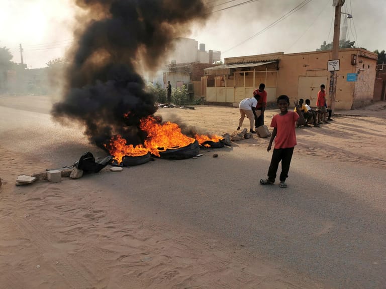 Brennende Straßenblockade während des Militärputsches: Im Oktober putschte sich im Sudan das Militär an die Macht. Zwar kehrte der Präsidenten kurz darauf zurück, die Massenproteste aber gingen weiter. Laut IRC könnte nun die bisherigen Bemühungen torpediert werden, Frieden mit aufständischen Gruppen zu schließen und die Wirtschaftskrise zu bekämpfen. Die Nahrungspreise liegen bereits bis zu 600 Prozent über dem Durchschnitt, knapp sechs Millionen Menschen sind von Lebensmittelknappheit bedroht.