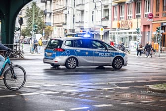 Ein Polizeiauto auf Einsatzfahrt mit Blaulicht in Berlin. (Symbolbild) Der verletzte Mitarbeiter wurde in ein Krankenhaus gebracht.