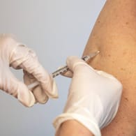 Eine Frau erhält eine Boosterimpfung: In Deutschland wird über die Einführung einer allgemeinen Impfpflicht gestritten.