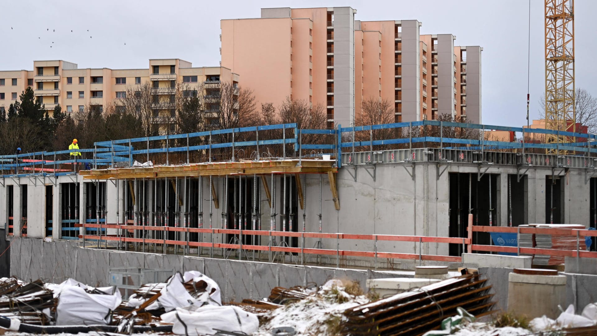 Eine Großbaustelle vor Wohnblöcken (Symbolbild): Die Renovierungsoffensive soll nicht nur Neubauten betreffen. Gerade Mieter in veralteten Wohnhäusern sollen davon profitieren.