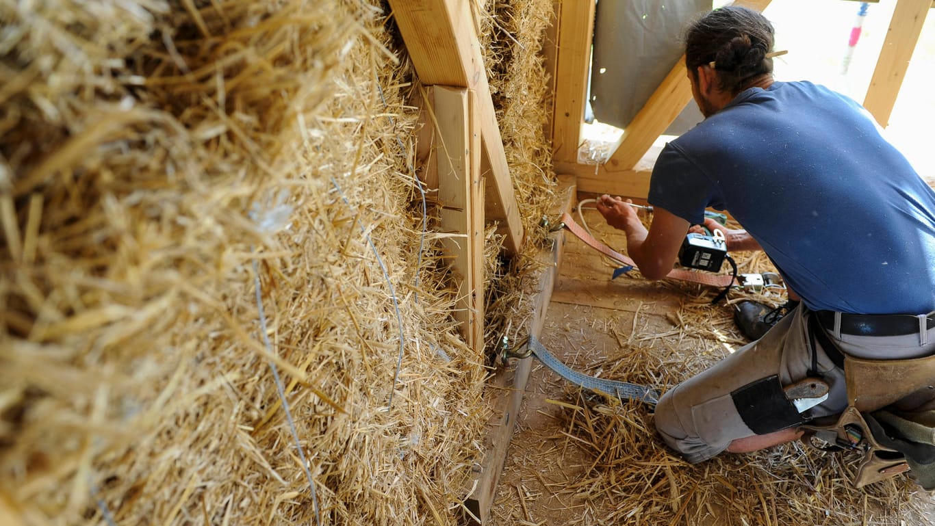 Ein Handwerker arbeitet im Rohbau eines Strohhauses in Salzwedel (Symbolbild): Für den Einsatz neuer Baustoffe und neuer Heiztechnik braucht es auch genügend ausgebildete Fachleute.
