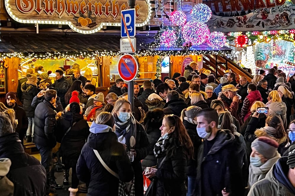 Menschen dicht gedrängt auf dem Weihnachtsmarkt: Mit der neuen Corona-Variante Omikron kommt eine Ansteckungswelle auf Deutschland zu.