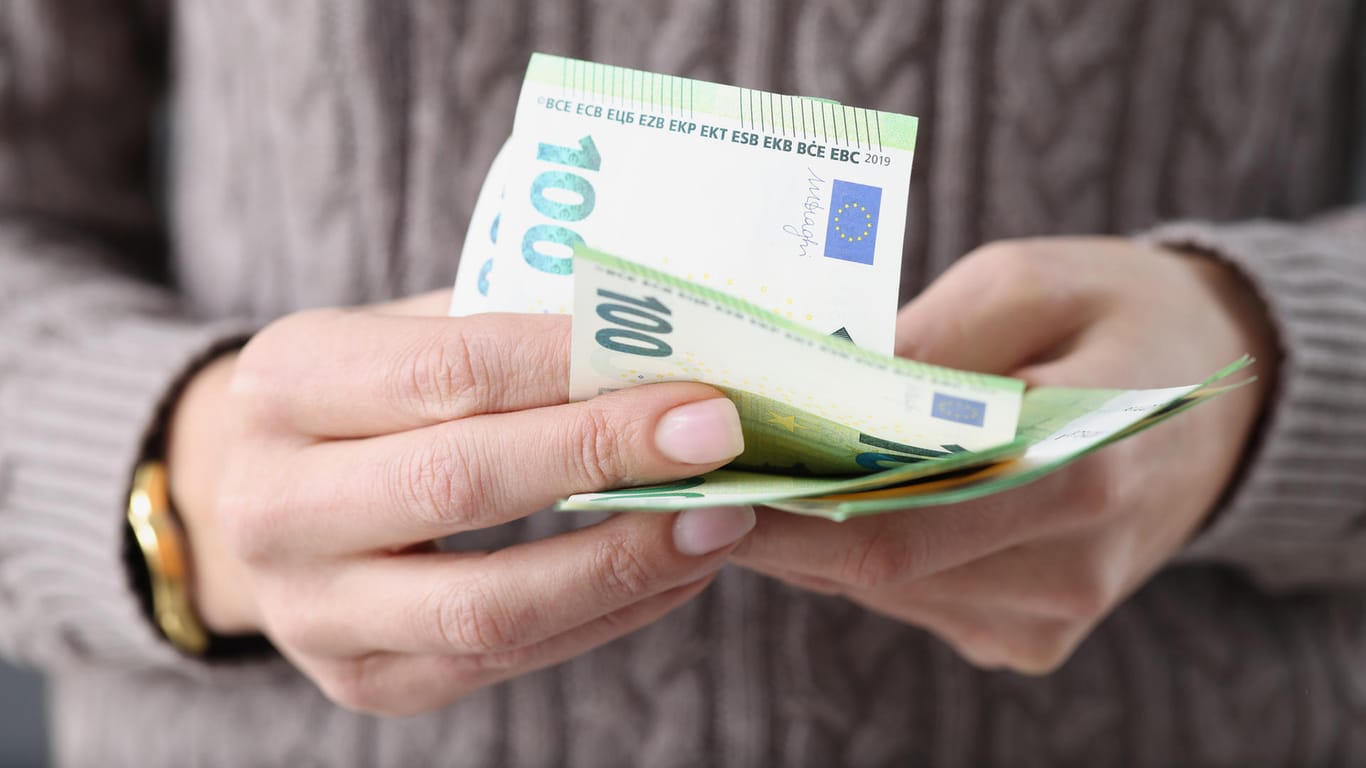 Eine Frau hält 100-Euro-Scheine (Symbolbild): Vermögen sind in Deutschland sehr ungleich verteilt. Eine neue Berechnung zeigt, wie sich das ändern ließe.