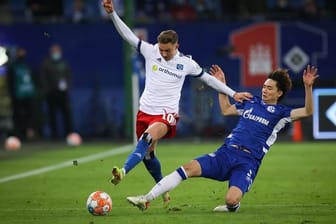 Schalkes Ko Itakura (r) setzt gegen Hamburgs Sonny Kittel zur Grätsche an.