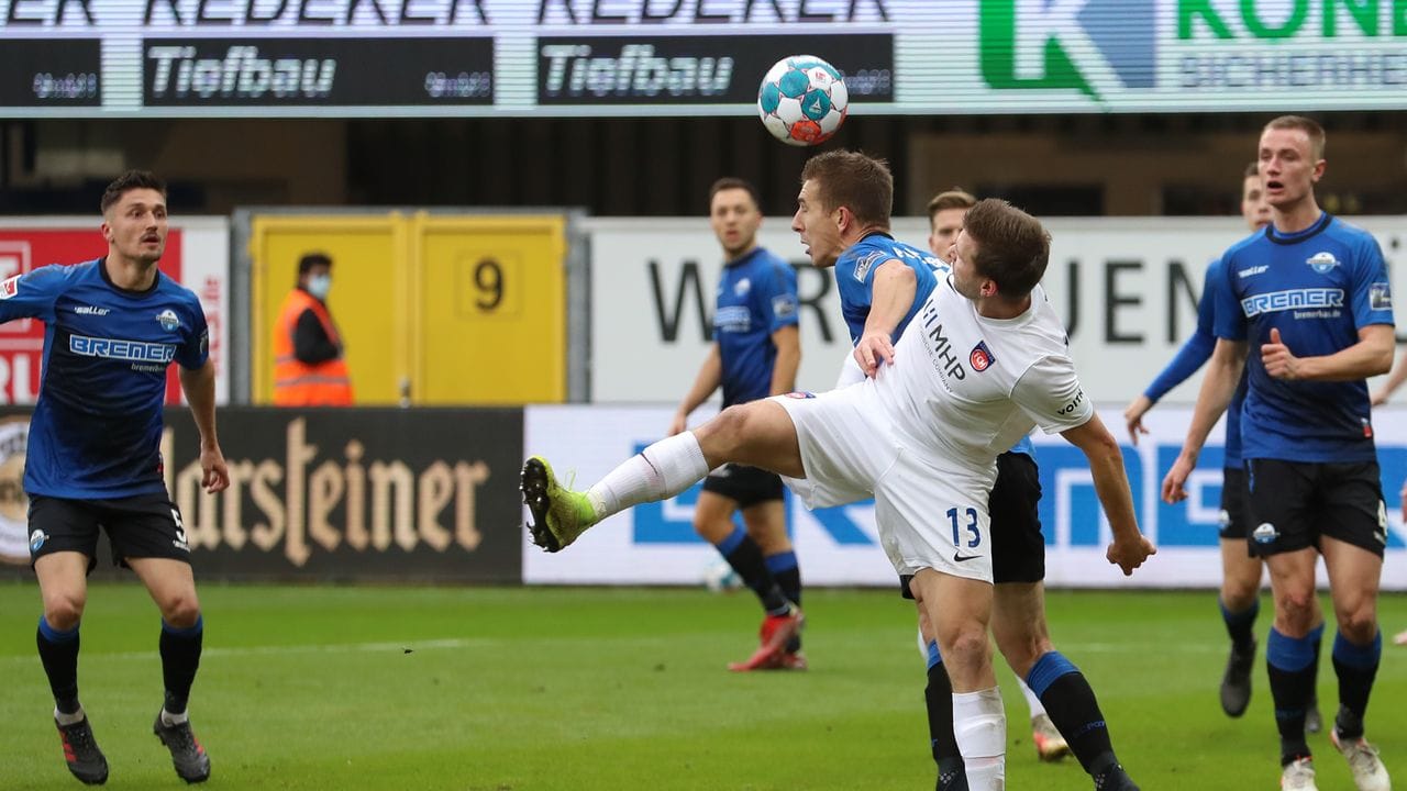 Paderborns Uwe Hünemeier (l) kommt im Zweikampf mit Heidenheims Robert Leipertz (r) vor diesem mit dem Kopf an den Ball. Paderborns Uwe Hünemeier (l) kommt im Zweikampf mit Heidenheims Robert Leipertz (r) vor diesem mit dem Kopf an den Ball.