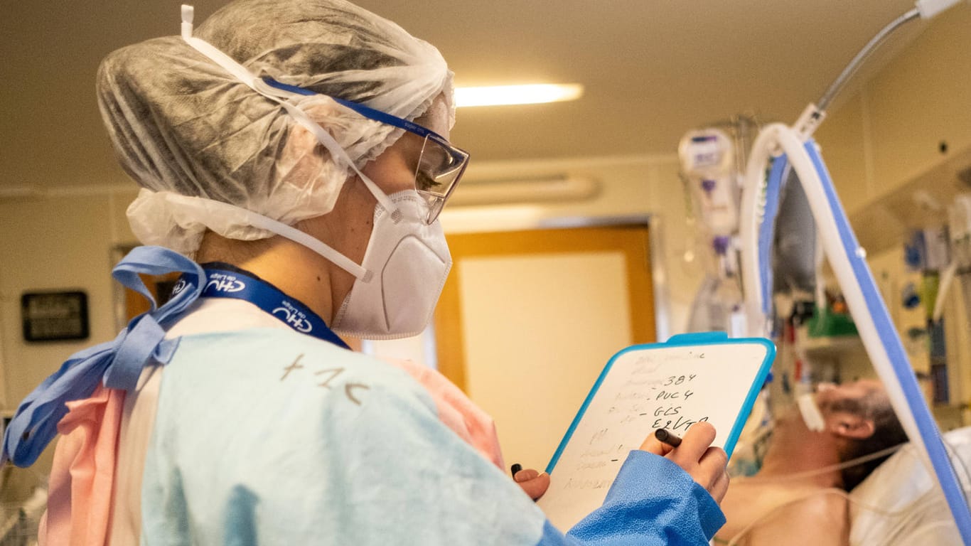 Eine Krankenschwester überwacht einen Covid-Patienten (Symbolbild): Mediziner in Großbritannien warnen, dass viel Personal wegen der Omikron-Variante ausfallen könnte.