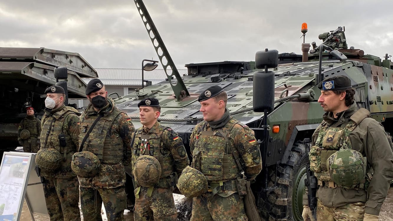 Ostflanke der Nato: Deutsche und niederländische Soldaten stehen vor einem gepanzerten Truppentransporter in Litauen.