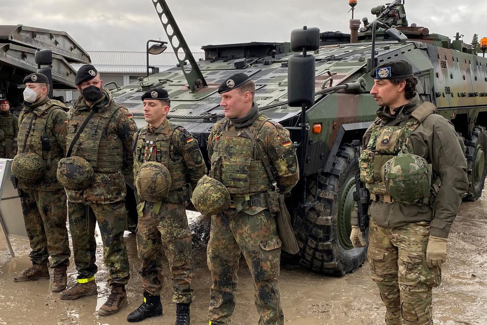 Ostflanke der Nato: Deutsche und niederländische Soldaten stehen vor einem gepanzerten Truppentransporter in Litauen.