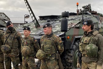 Ostflanke der Nato: Deutsche und niederländische Soldaten stehen vor einem gepanzerten Truppentransporter in Litauen.
