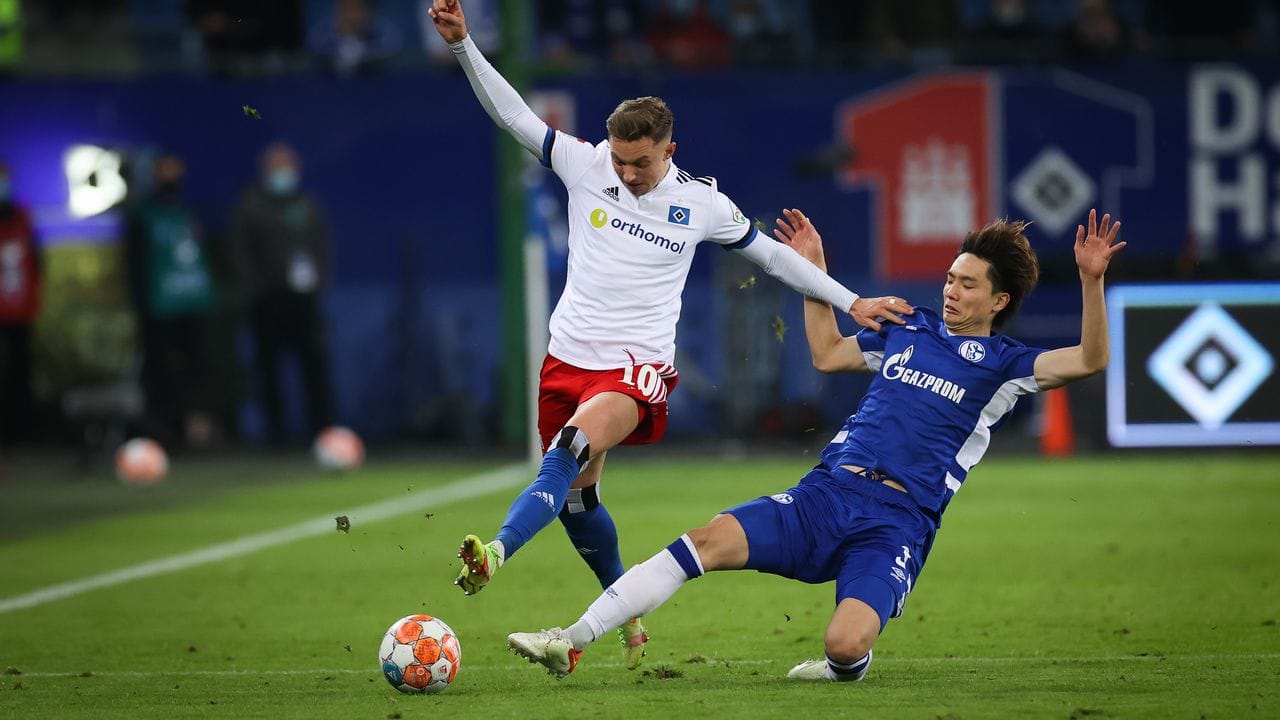 Schalkes Ko Itakura (r) setzt gegen Hamburgs Sonny Kittel zur Grätsche an. Schalkes Ko Itakura (r) setzt gegen Hamburgs Sonny Kittel zur Grätsche an.