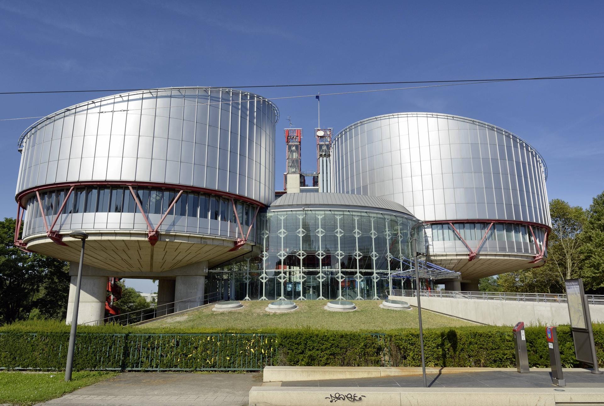 Der Europäische Gerichtshof für Menschenrechte in Straßburg, Frankreich: Das Gebäude, ebenso entworfen von Rogers, wurde nach dreijähriger Bauzeit im Jahr 1995 fertiggestellt. Aus der Luft betrachtet hat das Gebäude die Form einer Waage, wobei die runden Sitzungssäle die Waagschalen darstellen.