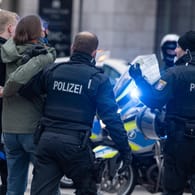 Polizisten nehmen in Frankfurt eine Teilnehmerin einer Demonstration gegen die derzeit geltenden Corona-Maßnahmen fest: Auch in Bremen war die Polizei am Wochenende gefordert.