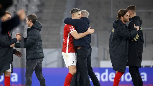 Freiburgs Trainer Christian Streich (Mitte rechts) umarmt Freiburgs Nico Schlotterbeck (Mitte links) nach Spielende. Freiburgs Trainer Christian Streich (Mitte rechts) umarmt Freiburgs Nico Schlotterbeck (Mitte links) nach Spielende.