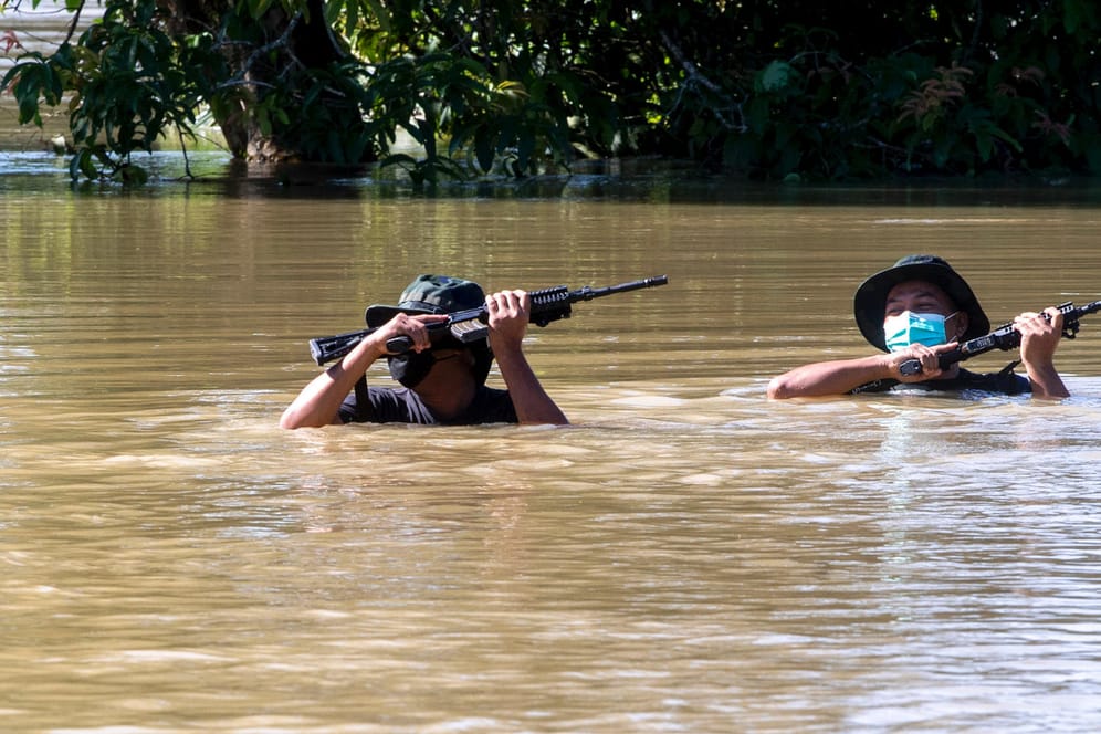 Soldaten waten durch eine überflutete Straße: In Malaysia gibt es nach schweren Überschwemmungen dutzende Tote und Vermisste.