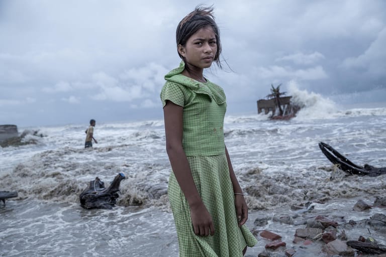 Das Siegerbild 2021 "Im Auge des Sturms" des indischen Fotografen Supratim Bhattacharjee zeigt die elfjährige Pallavi in einem tropischen Wirbelsturm, der das Ganges-Delta aufwühlt. Der Sturm hat die komplette Existenz von Pallavi und ihrer fünfköpfigen Familie fortgerissen.
