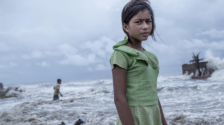 Das Siegerbild 2021 "Im Auge des Sturms" des indischen Fotografen Supratim Bhattacharjee zeigt die elfjährige Pallavi in einem tropischen Wirbelsturm, der das Ganges-Delta aufwühlt. Der Sturm hat die komplette Existenz von Pallavi und ihrer fünfköpfigen Familie fortgerissen.