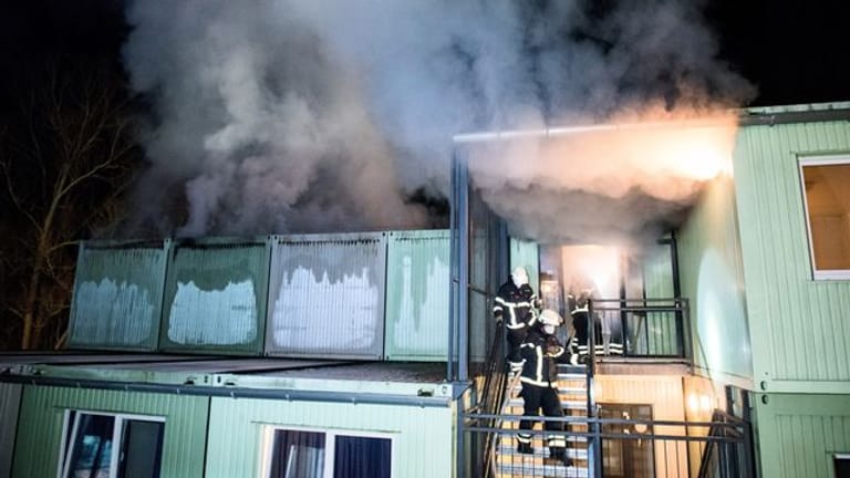Feuerwehrleute löschen im Stadtteil Bergedorf einen Brand in einer Wohnunterkunft: Noch ist unklar, wie es zu dem Brand kam.
