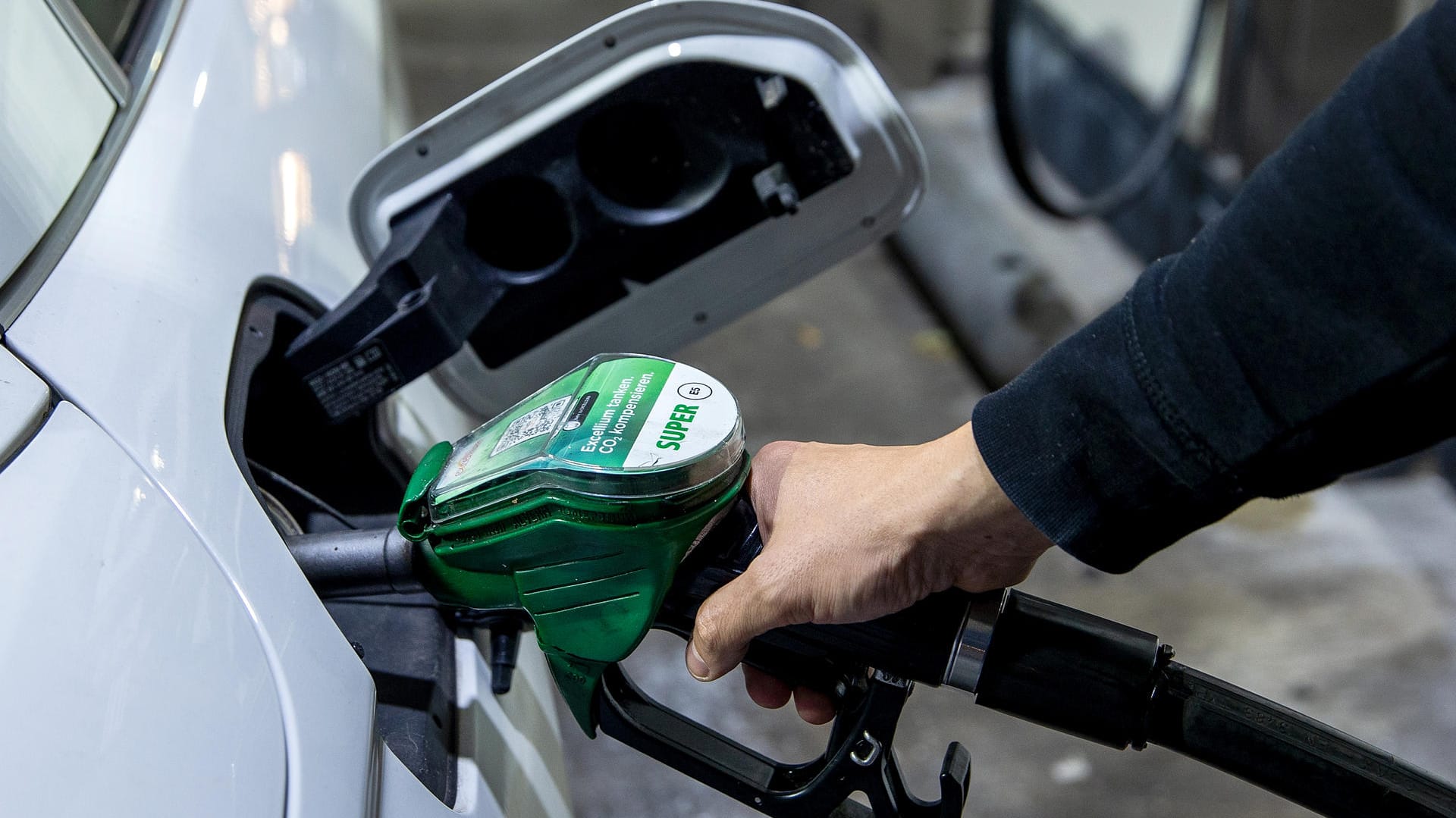 Ein Autofahrer beim Tanken (Symbolbild): Besonders die hohen Spritkosten treiben die Teuerung an.