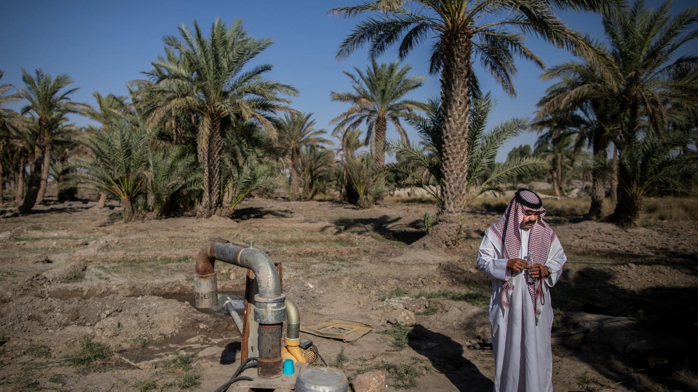 Ein Mann steht neben einem Bewässerungssystem, das die irakische Oase Rahalija mit Wasser versorgt (Archivbild): Eine unterirdische Quelle speist das Becken seit Jahrhunderten mit Wasser, doch mittlerweile ist das Becken nur noch weniger als zur Hälfte gefüllt.