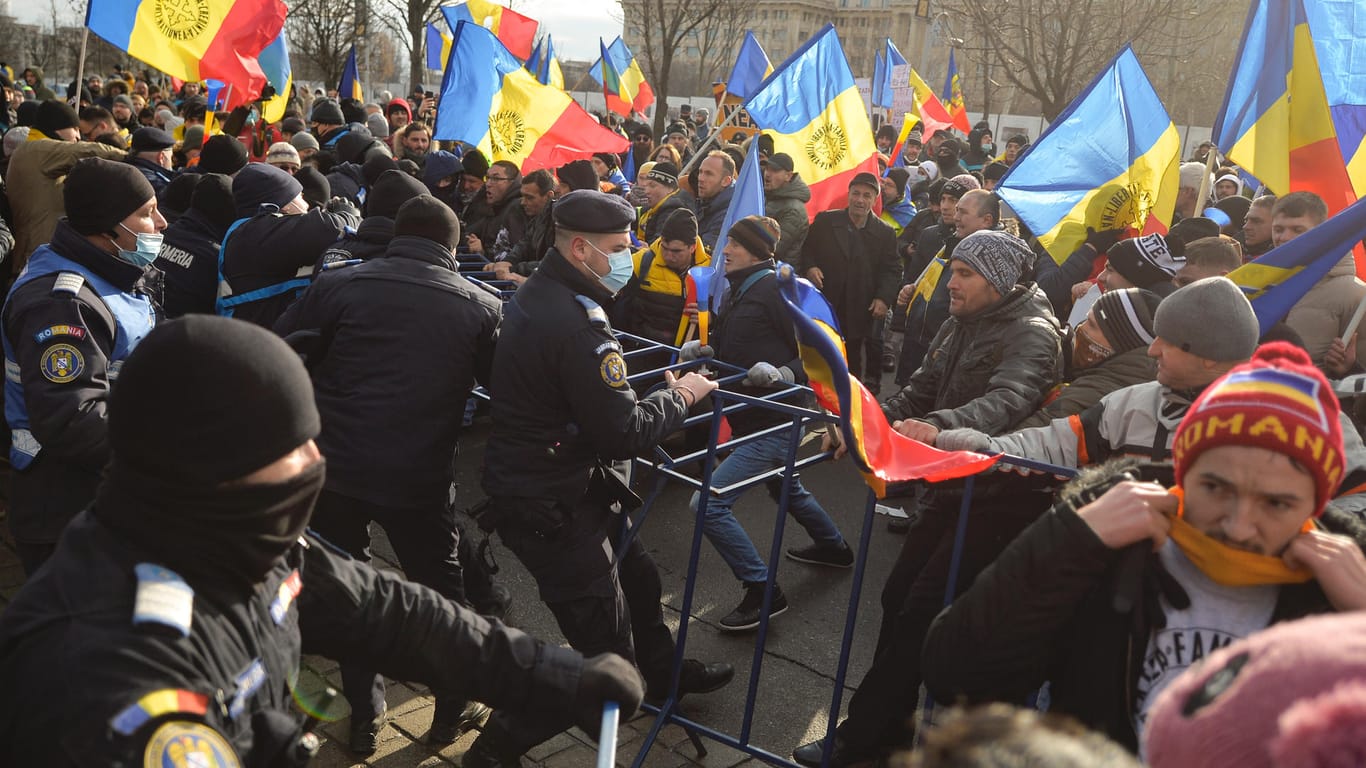 Rumänien, Bukarest: Polizisten versuchen, Demonstranten vor dem Parlamentsgebäude abzuwehren.