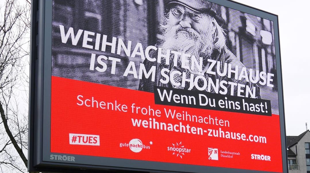 Eine digitale Plakatwand informiert über die Aktion: Für 10 Euro erhält eine obdachloser Mensch ein Weihnachtsgeschenk. Eine digitale Plakatwand informiert über die Aktion: Für 10 Euro erhält eine obdachloser Mensch ein Weihnachtsgeschenk.