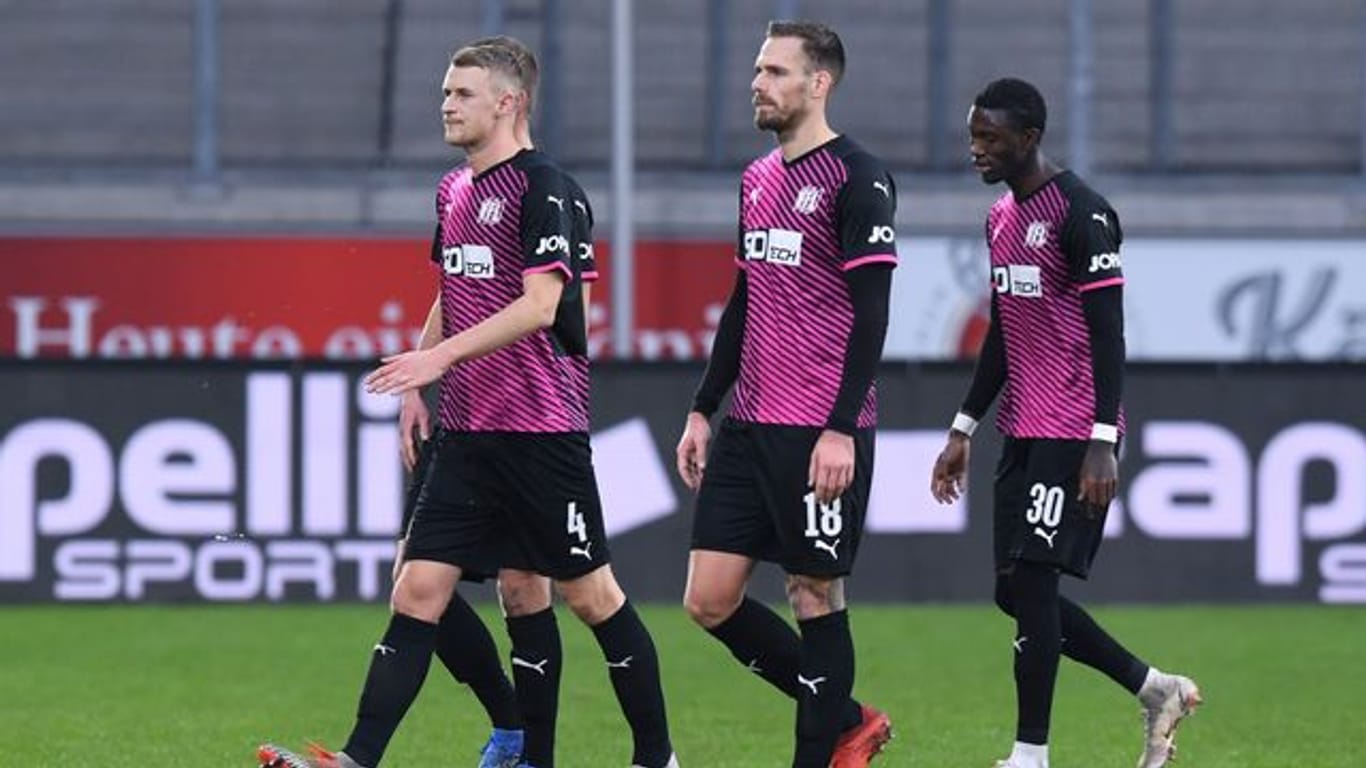 Osnabrücks Aaron Opoku (r) verlässt nach rassistischen Beleidigungen von den Zuschauerrängen mit Teamkollegen das Spielfeld.