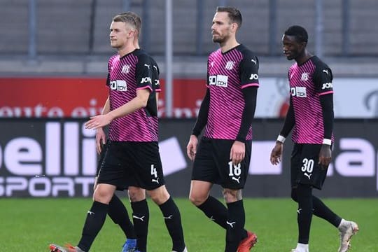 Osnabrücks Aaron Opoku (r) verlässt nach rassistischen Beleidigungen von den Zuschauerrängen mit Teamkollegen das Spielfeld.