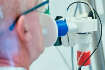 Ein von einer Corona-Erkrankung genesener Patient bekommt die Lungenfunktion gemessen: Die Inzidenz in Deutschland liegt jetzt wieder unter 300.
