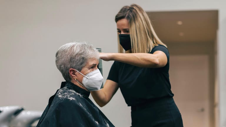 Frau lässt sich beim Friseur die Haare schneiden: Selbstständige sollen Corona-Hilfen zurückzahlen müssen.