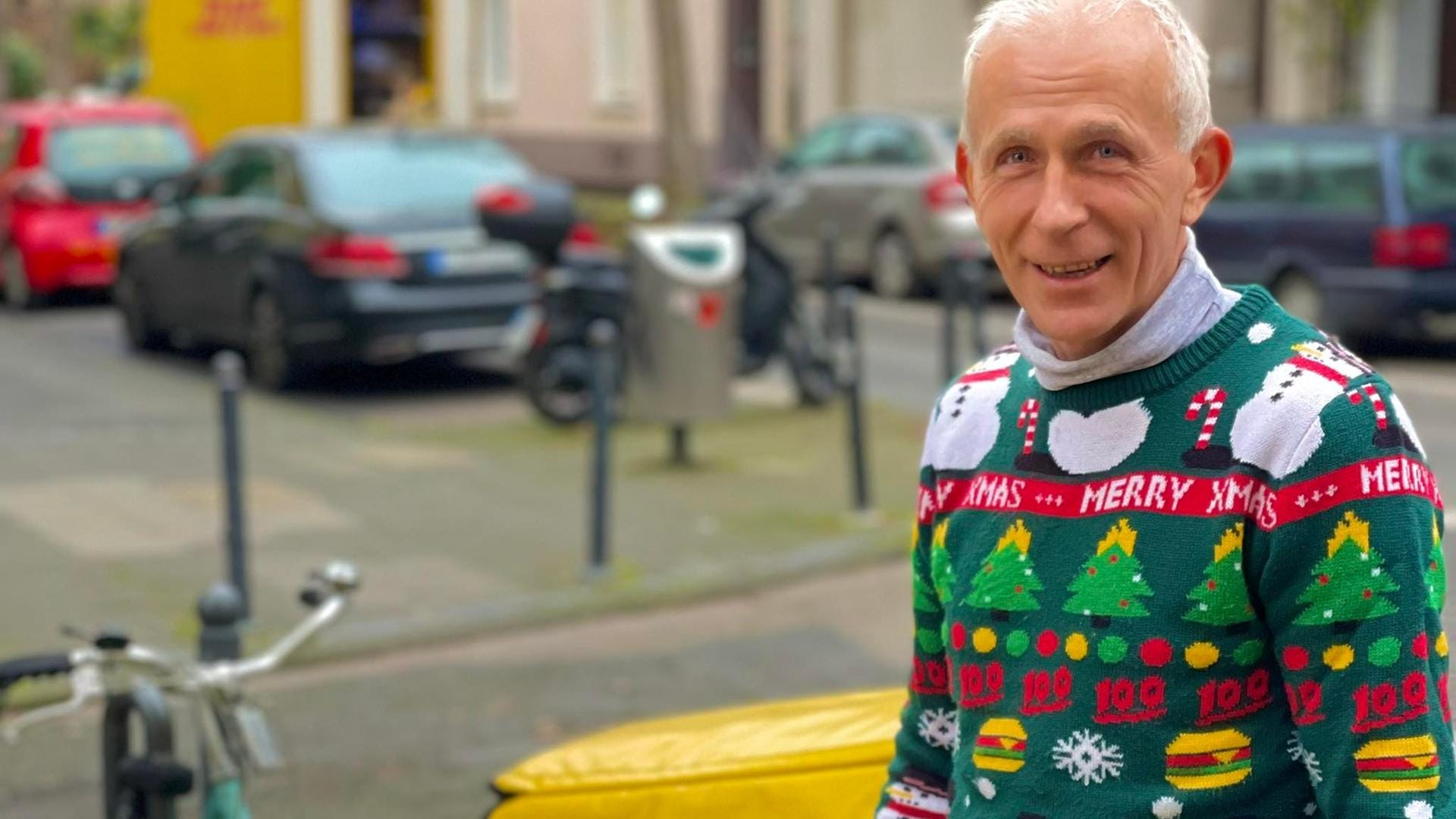 Eugen Mularczyk beliefert seit 33 Jahren die Menschen des Sechzigviertels: Besonders bekannt ist er für die bunten Weihnachstspullis, die er jedes Jahr trägt.