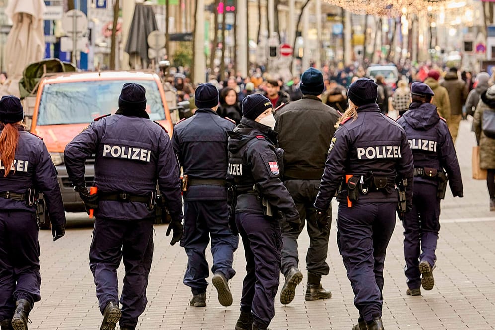 Polizeibeamte kontrollieren in einer Fußgängerzone (Symbolbild): Verstöße gegen die Corona-Regeln haben Bußgelder in Millionenhöhe in städtische Haushalte in NRW gespült.