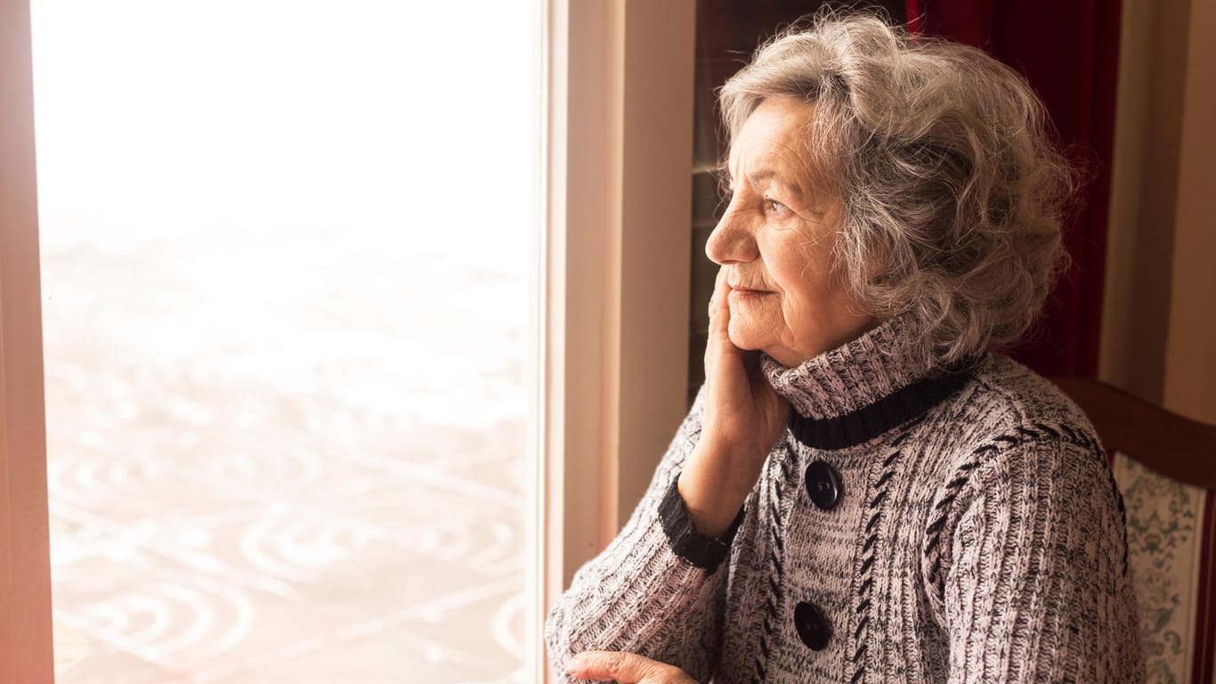 Ältere Frau blickt durchs Fenster (Symbolbild): 2022 hält einige Änderungen für Senioren parat.