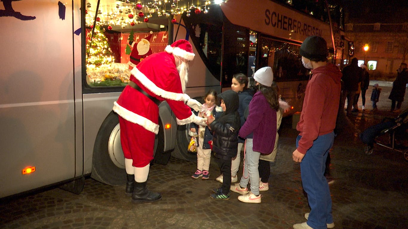 Kinder bekommen am Marktplatz von Ahrweiler Geschenke vom Weihnachtsmann: Im Kostüm steckt ein Busfahrer aus dem Hunsrück.