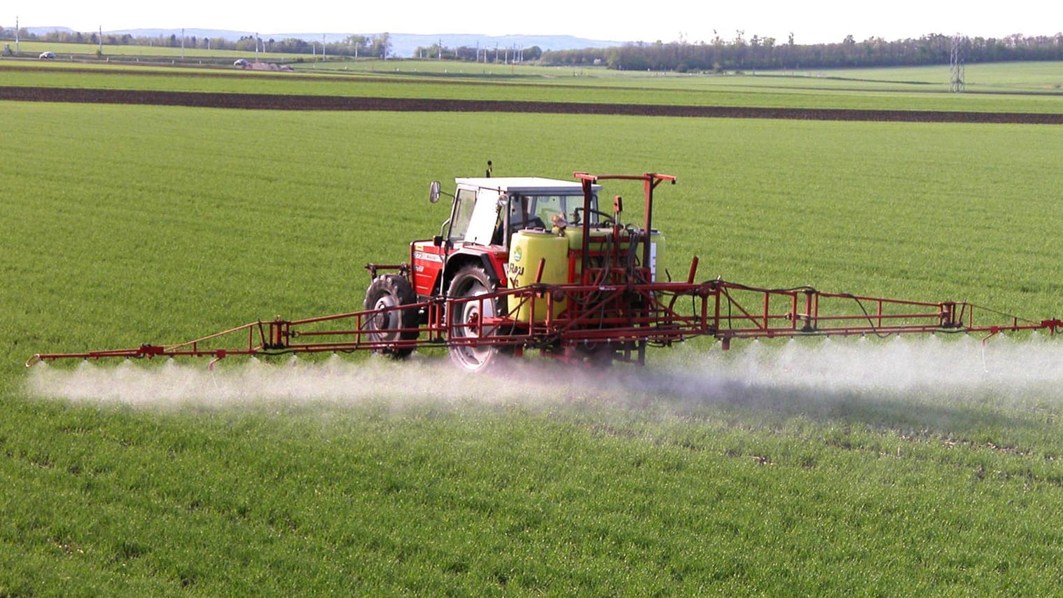 Ein Traktor versprüht Pestizide auf einem Feld (Symbolbild): Die Preise für Dünger dürften absehbar stark steigen.