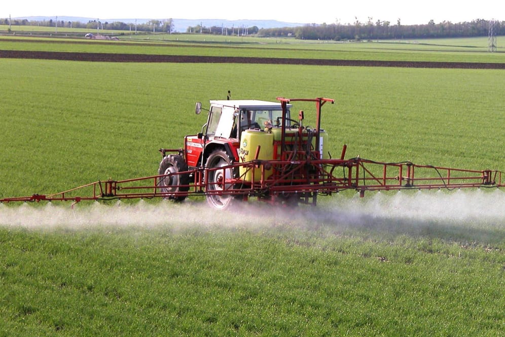 Ein Traktor versprüht Pestizide auf einem Feld (Symbolbild): Die Preise für Dünger dürften absehbar stark steigen.